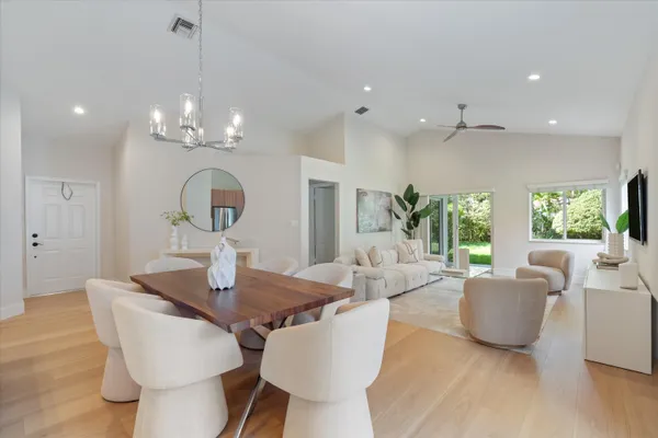 a living room with furniture a flat screen tv and a large window