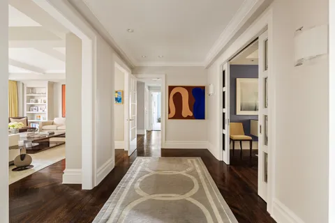 a view of a hallway with wooden floor and windows