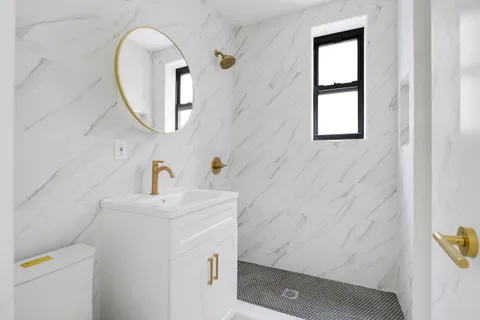 a bathroom with a sink a toilet and a mirror