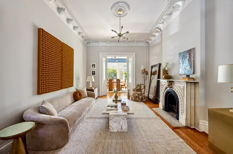 a living room with furniture a fireplace and a chandelier