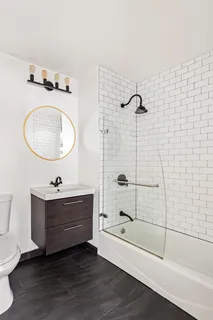 a bathroom with a tub sink toilet and mirror