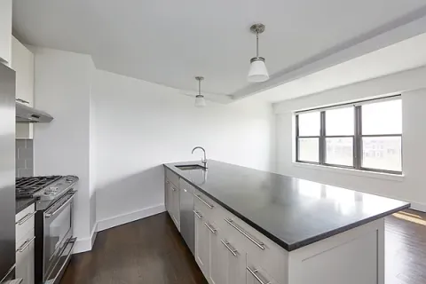 a kitchen with stainless steel appliances granite countertop a sink a stove and a refrigerator