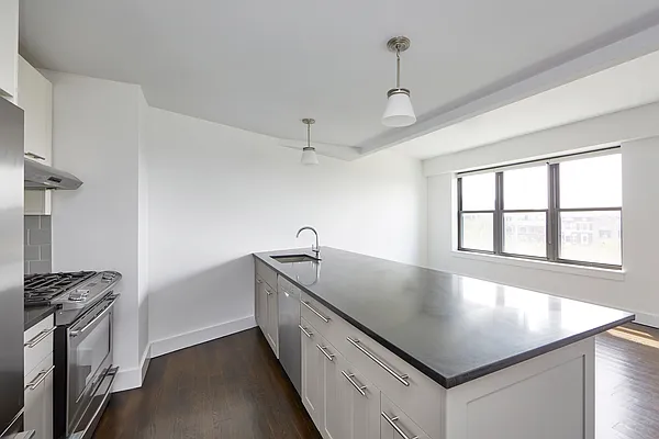 a kitchen with stainless steel appliances granite countertop a sink a stove and a refrigerator