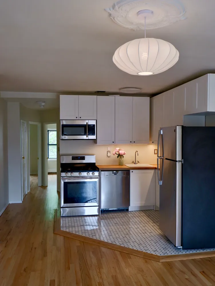 a large kitchen with stainless steel appliances a stove refrigerator sink and cabinets
