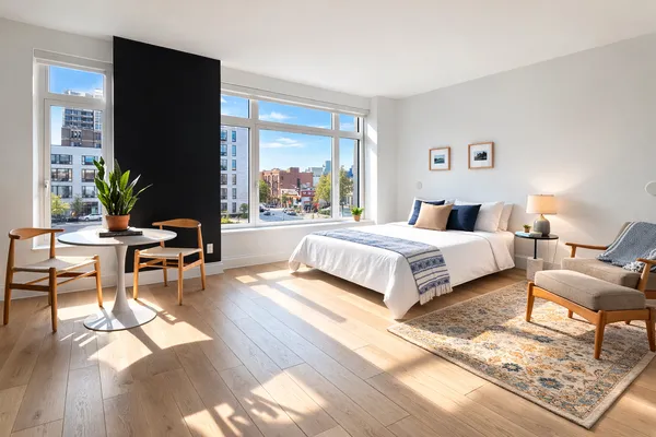 a spacious bedroom with a bed a couch and a potted plant on the table