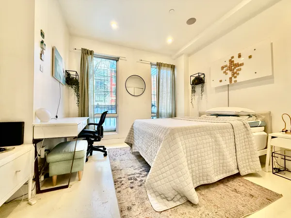 a bedroom with a bed and wooden floor