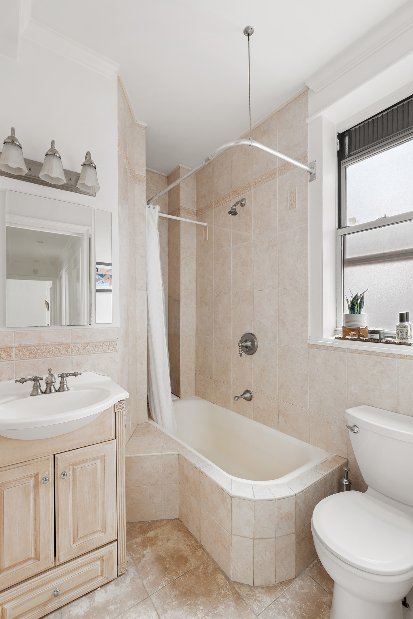 16 East 98th Street, Unit 7F Manhattan, NY 10029 - Photo 5 of 8 a bathroom with a sink a toilet a mirror and a bathtub