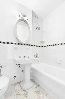 a bathroom with a tub sink and mirror