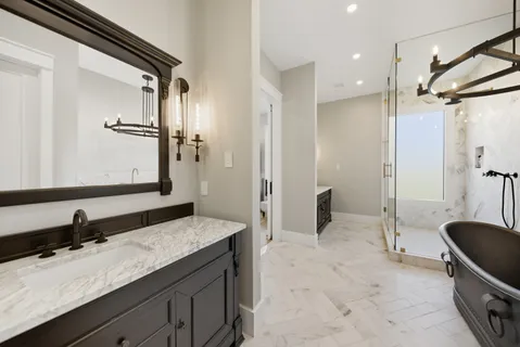 a bathroom with a granite countertop sink mirror and a shower