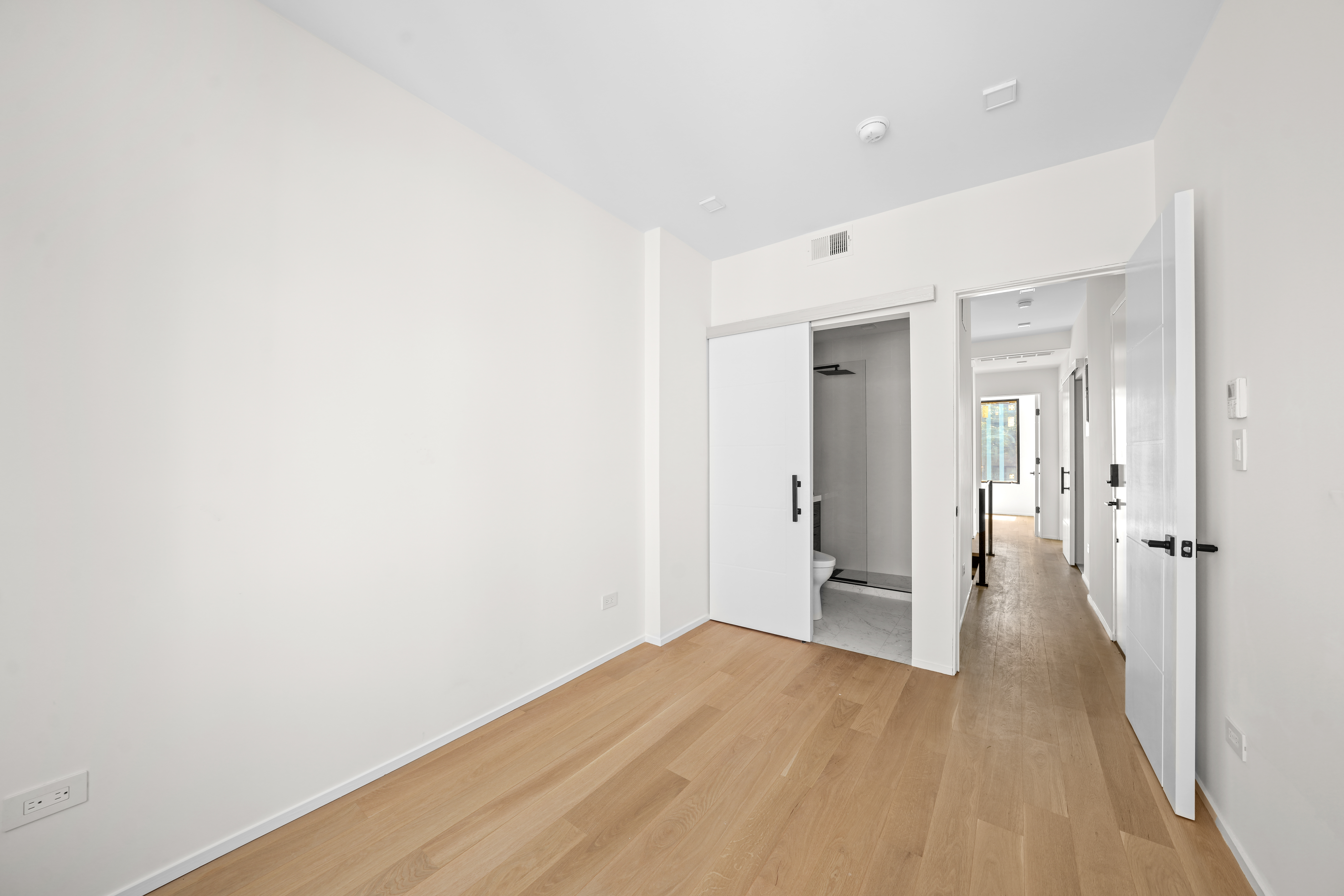 953 St Nicholas Avenue, Unit 1 Manhattan, NY 10032 - Photo 9 of 15 a view of a hallway with wooden floor and a bathroom