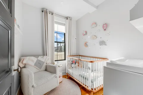 a view of a bedroom with furniture and baby crib