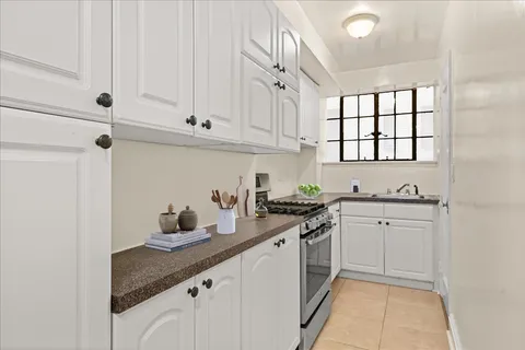 a kitchen with granite countertop white cabinets and white appliances