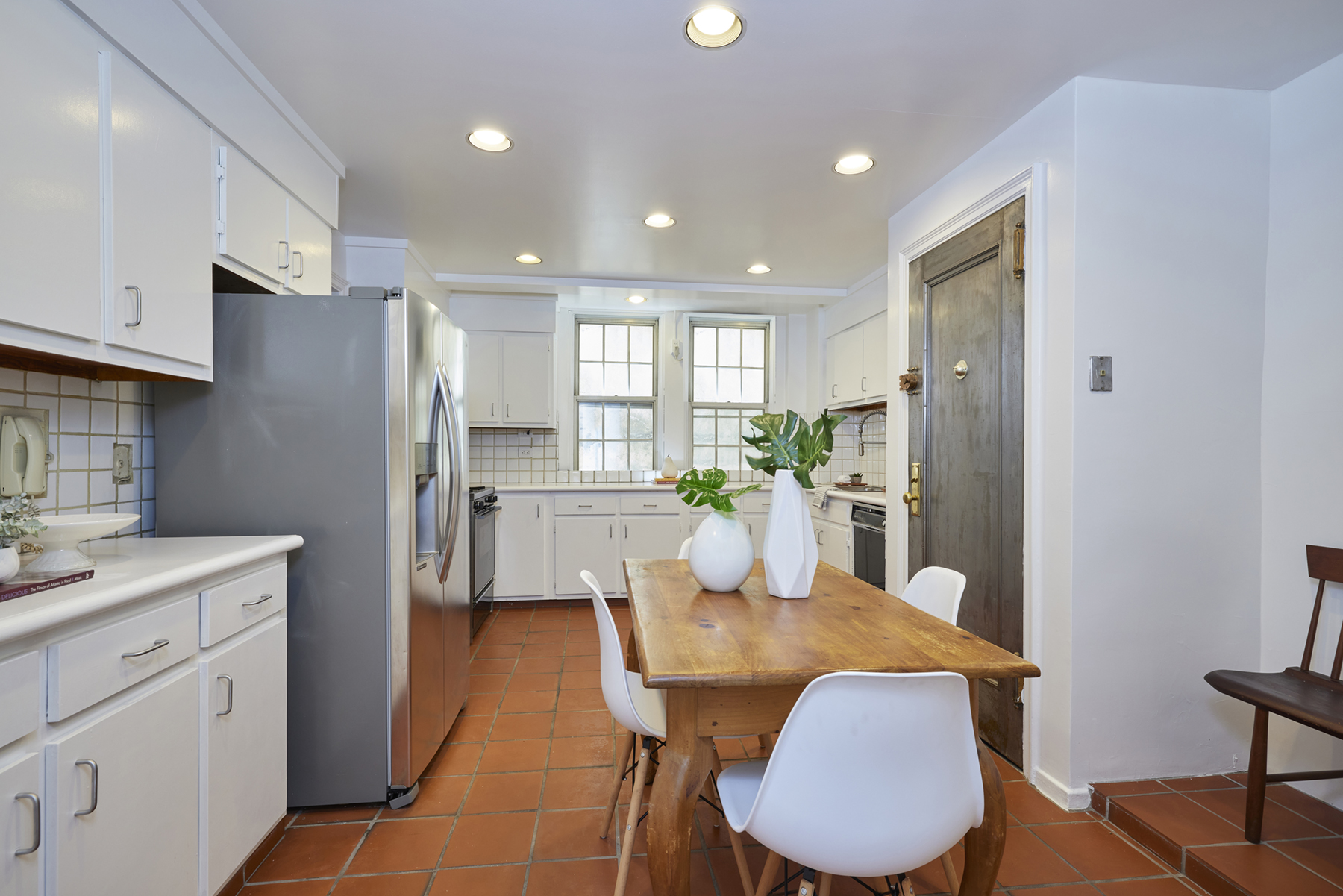 520 East 86th Street, Unit 2D Manhattan, NY 10028 - Photo 5 of 15 a kitchen with stainless steel appliances granite countertop a refrigerator a sink dishwasher a stove a dining table and chairs with wooden floor