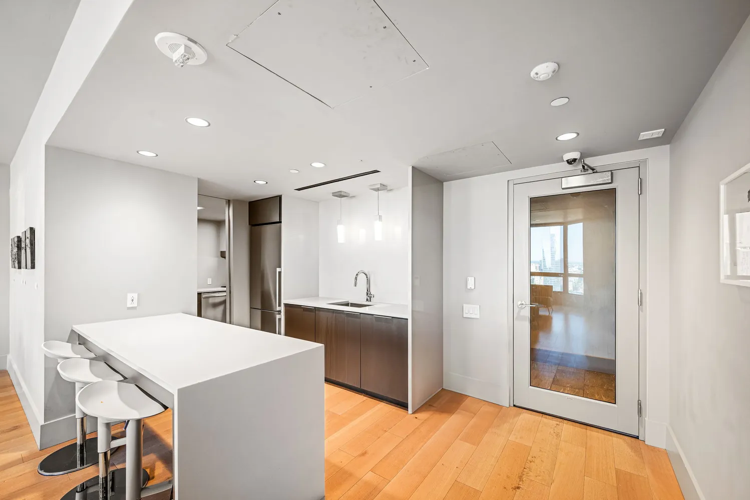 a living room with furniture a flat screen tv and kitchen view