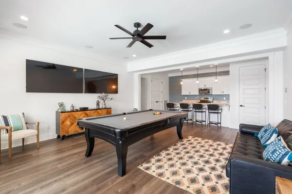 a kitchen with stainless steel appliances a stove a sink a microwave a center island and a wooden floor