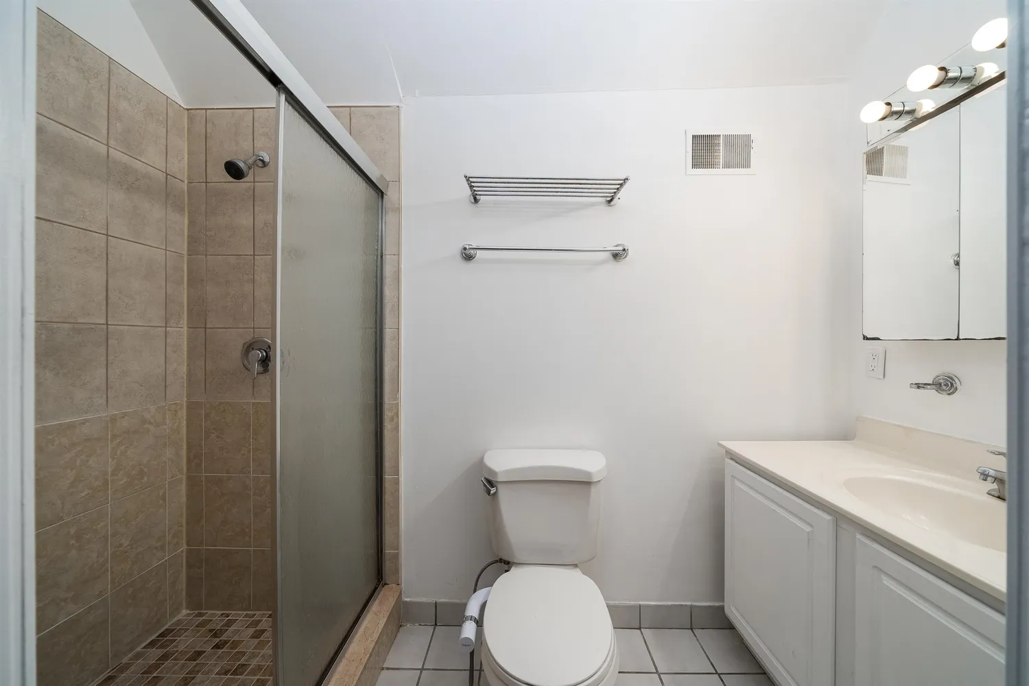 a bathroom with a sink a toilet and shower