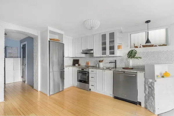 a kitchen with stainless steel appliances granite countertop a refrigerator a stove a sink dishwasher and white cabinets with wooden floor