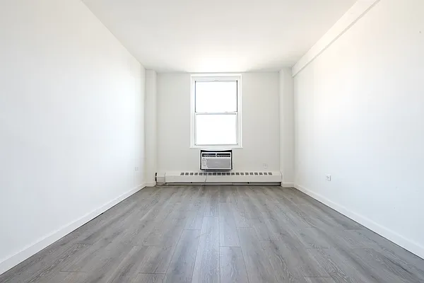 148 Cozine Avenue, Unit 1C Brooklyn, NY 11207 - Photo 5 of 8 an empty room with wooden floor and windows
