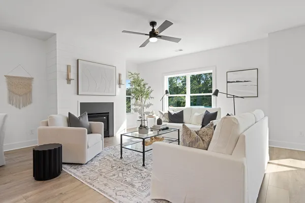 a living room with furniture a fireplace and a large window