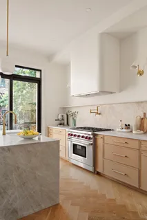 a view of an empty room with wooden floor and window