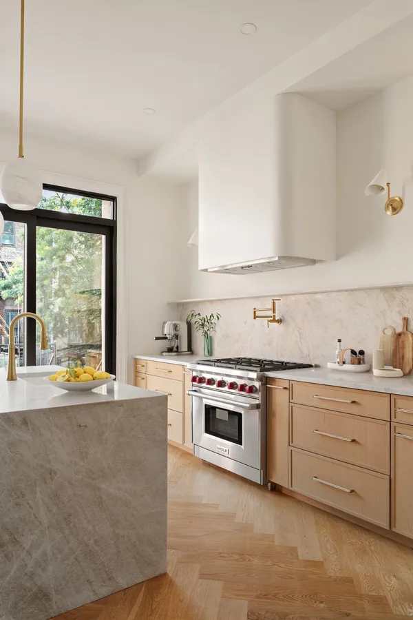 a view of an empty room with wooden floor and window