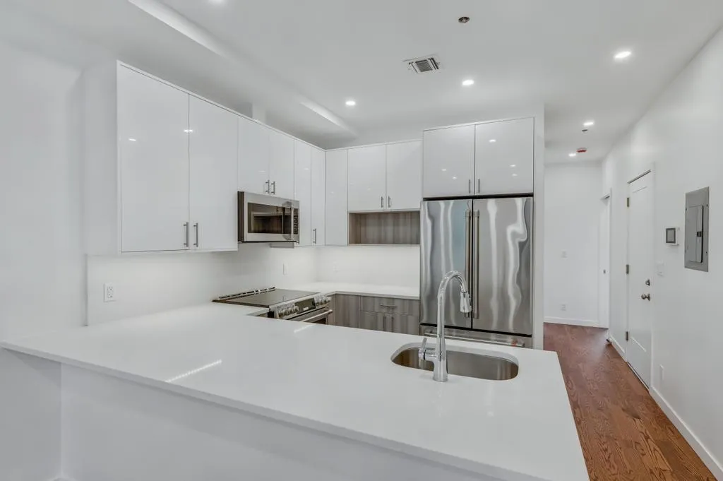 a kitchen with stainless steel appliances granite countertop a refrigerator and a sink