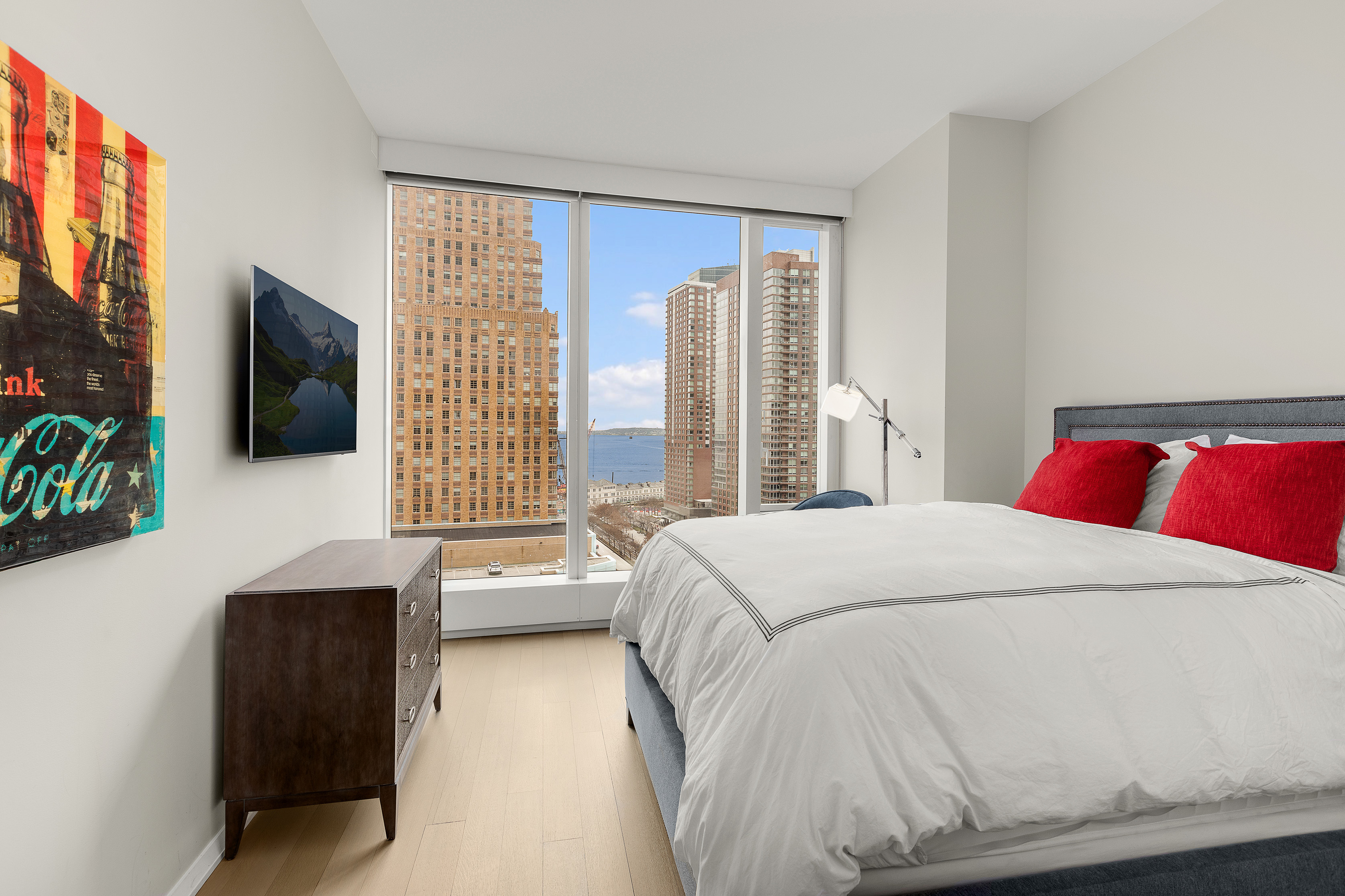 50 West Street, Unit 14B Manhattan, NY 10006 - Photo 9 of 29 a bedroom with a bed and a flat screen tv