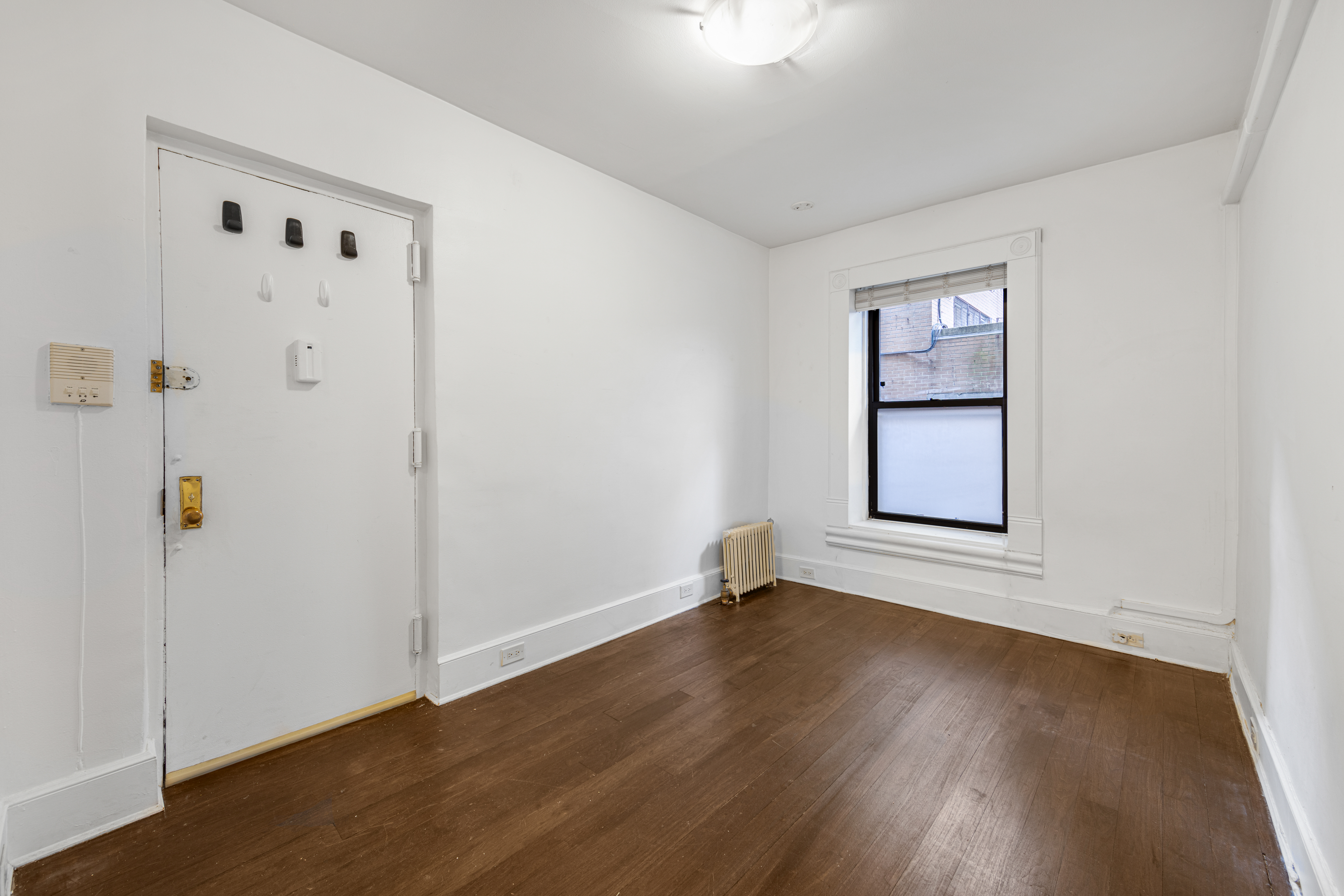 241 Mulberry Street, Unit 3 Manhattan, NY 10012 - Photo 5 of 8 an empty room with wooden floor and windows