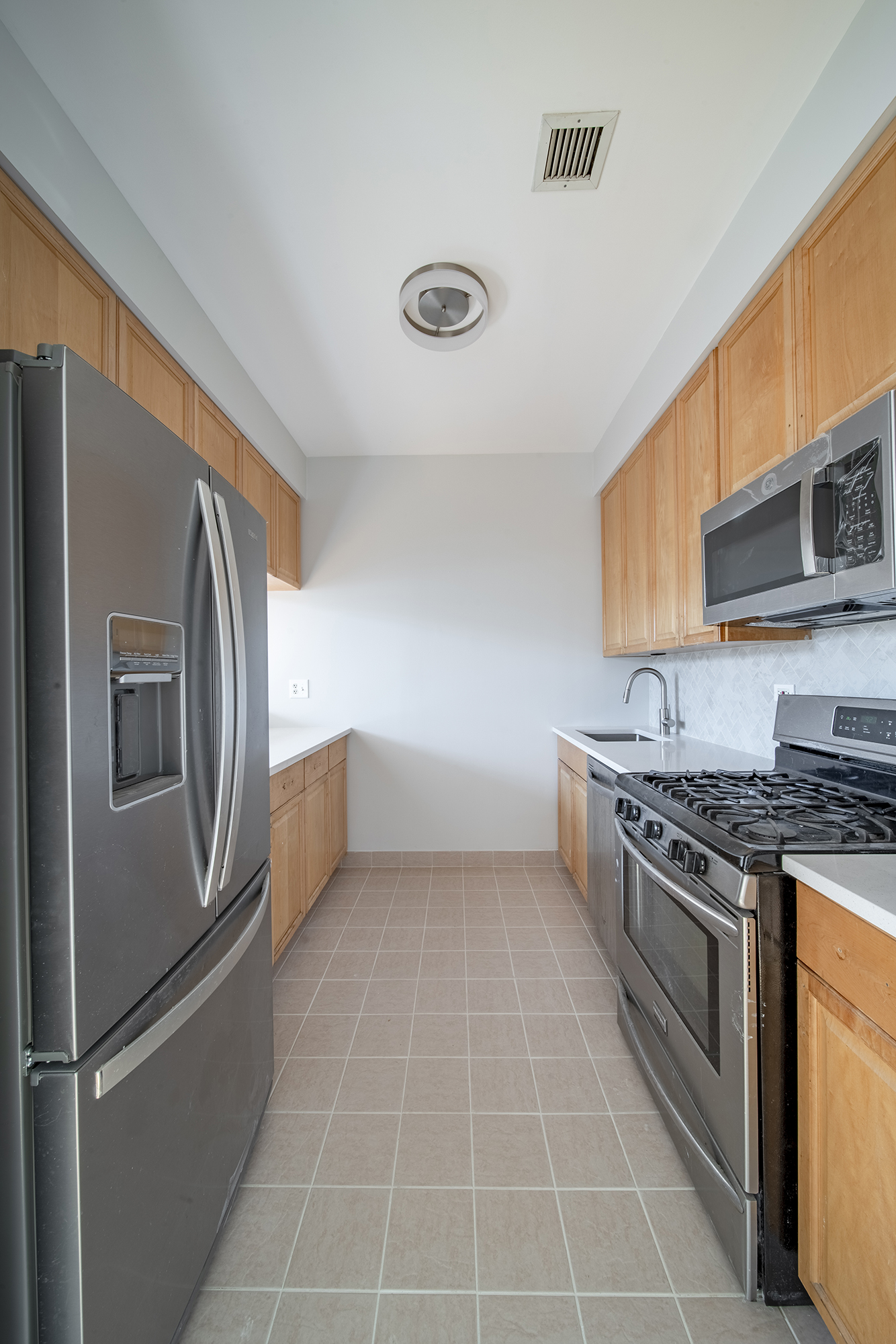 7 Mt Morris Park West, Unit D Manhattan, NY 10027 - Photo 3 of 16 a kitchen with granite countertop a refrigerator and a stove top oven