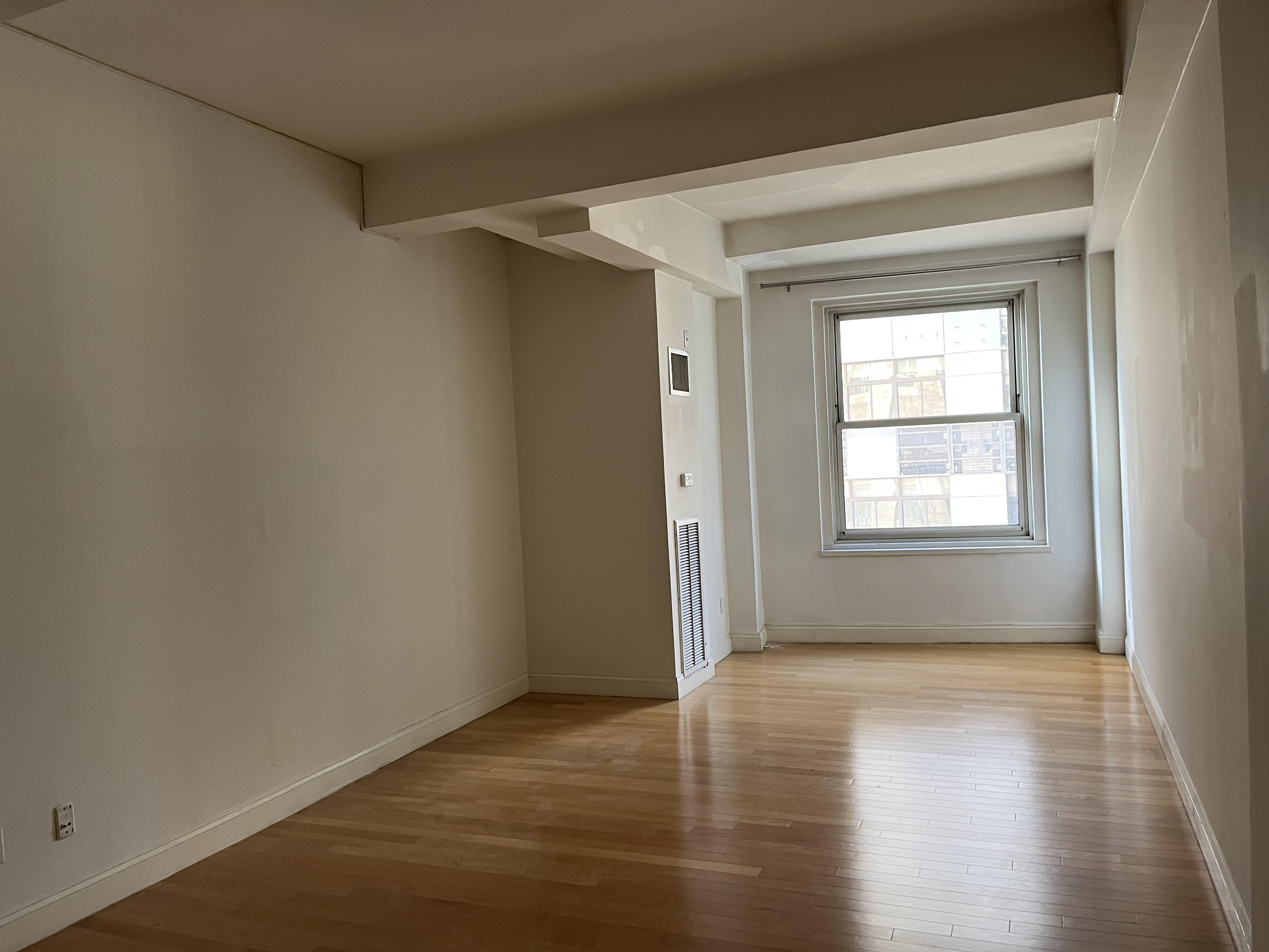 88 Greenwich Street, Unit 821 Manhattan, NY 10006 - Photo 1 of 10 a view of an empty room with wooden floor and a window