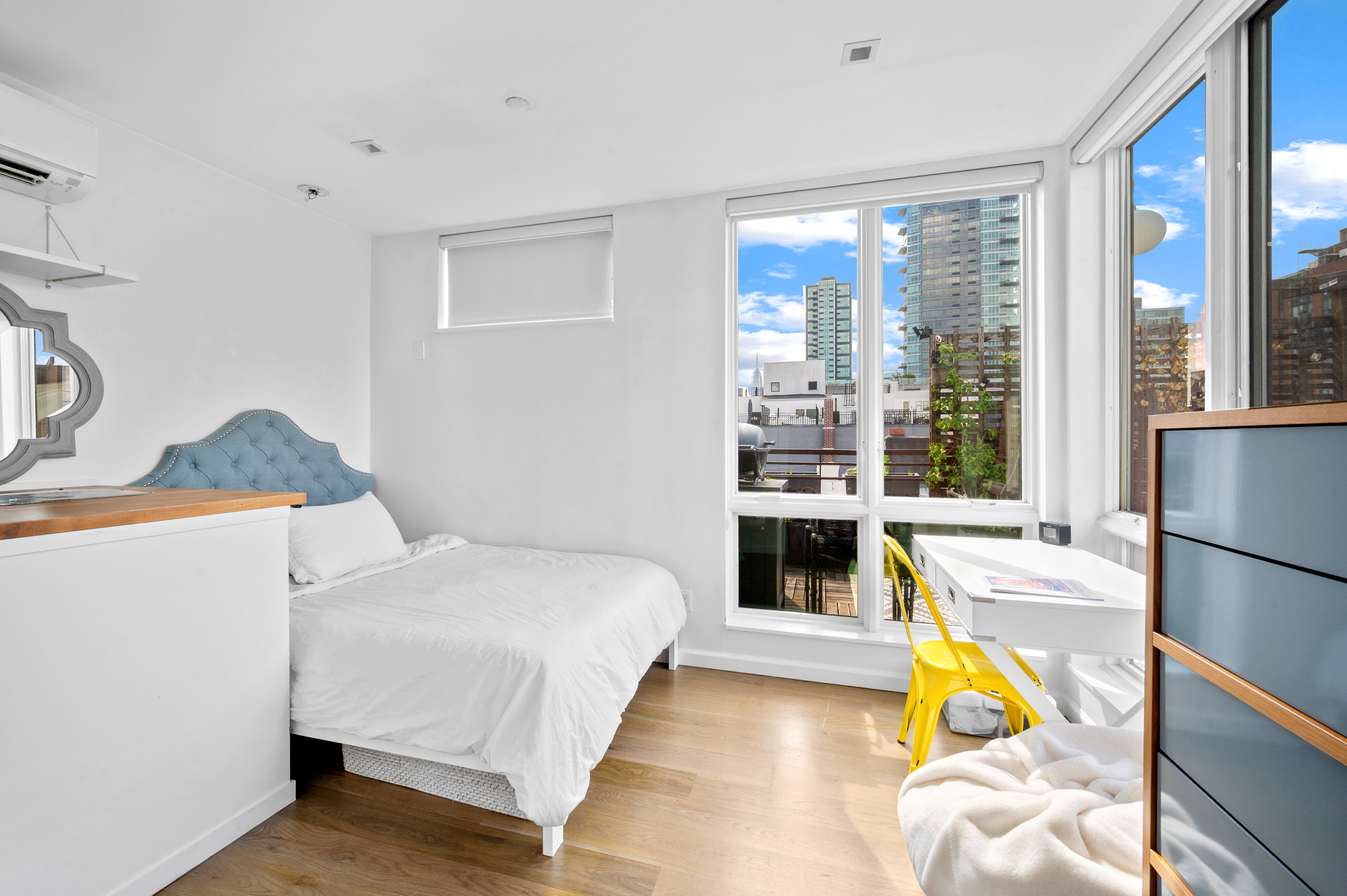 5-41 47th Road, Unit 2B Queens, NY 11101 - Photo 8 of 10 a bedroom with a bed and a large window