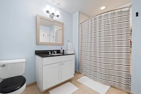 a bathroom with a toilet a sink and mirror