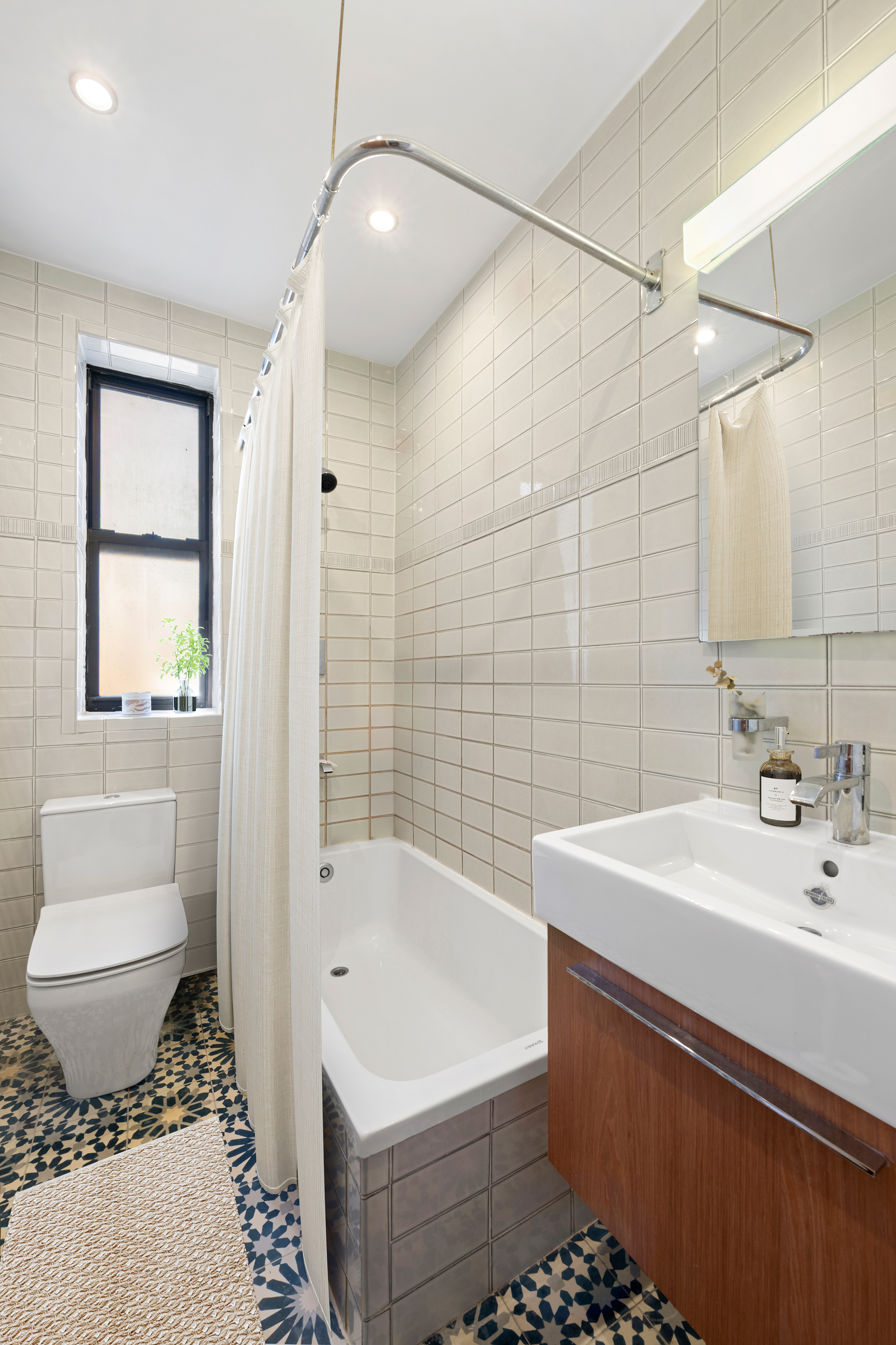 315 East 88th Street, Unit 5E Manhattan, NY 10128 - Photo 6 of 8 a bathroom with a sink toilet and shower