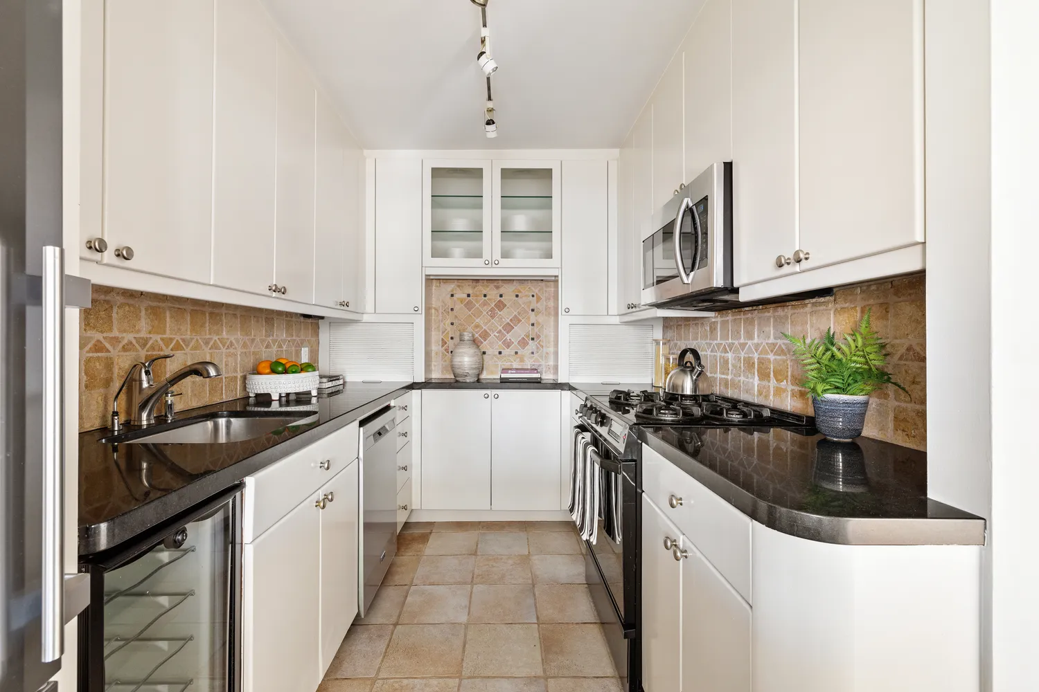 a kitchen with granite countertop a sink stove and cabinets
