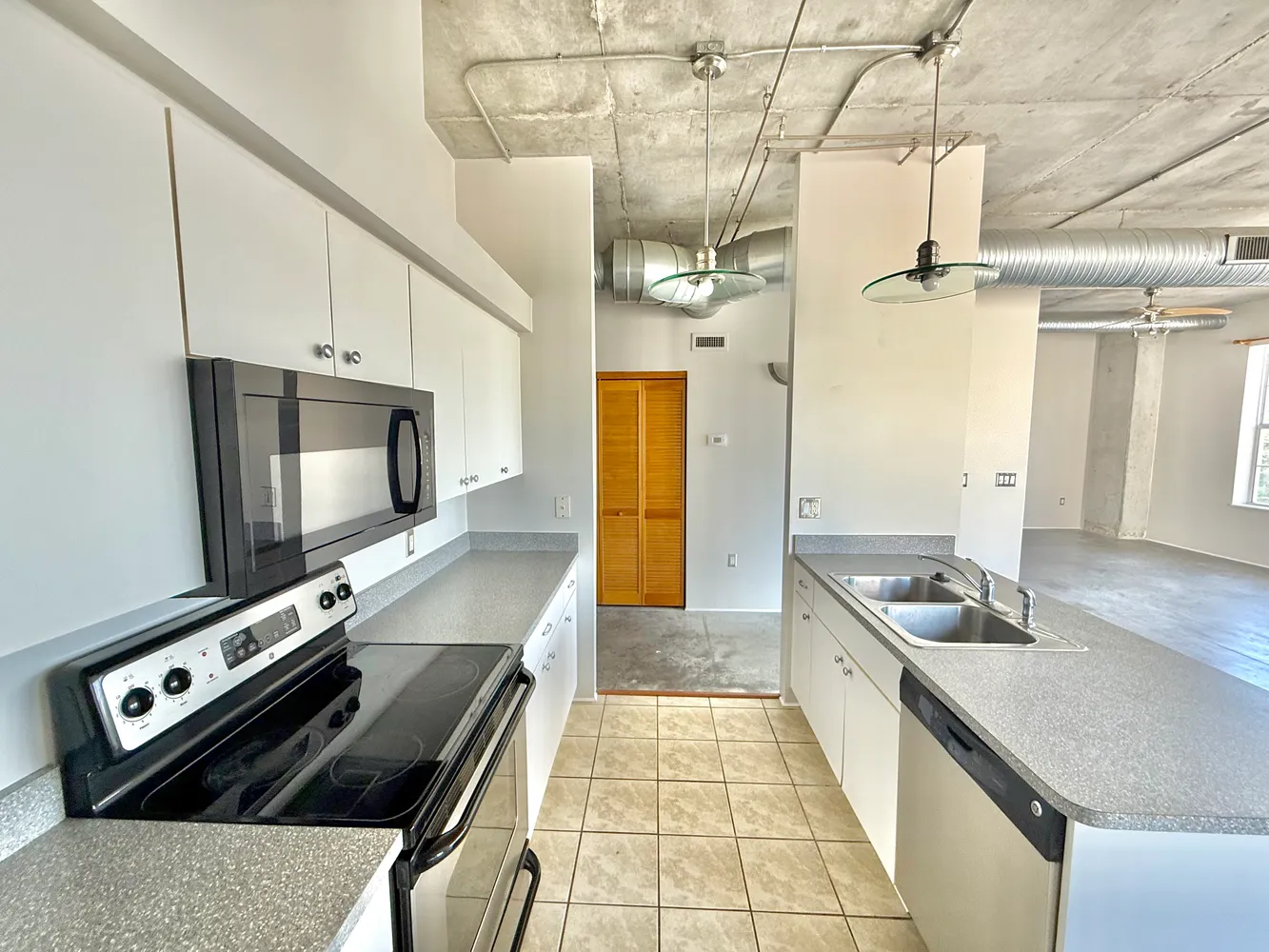 a kitchen with stainless steel appliances granite countertop a sink a stove and a refrigerator