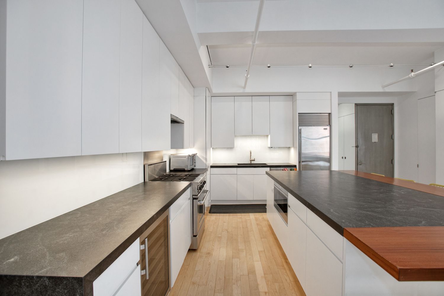62 Cooper Square, Unit 4C Manhattan, NY 10003 - Photo 2 of 7 a kitchen with a stove a sink and a refrigerator