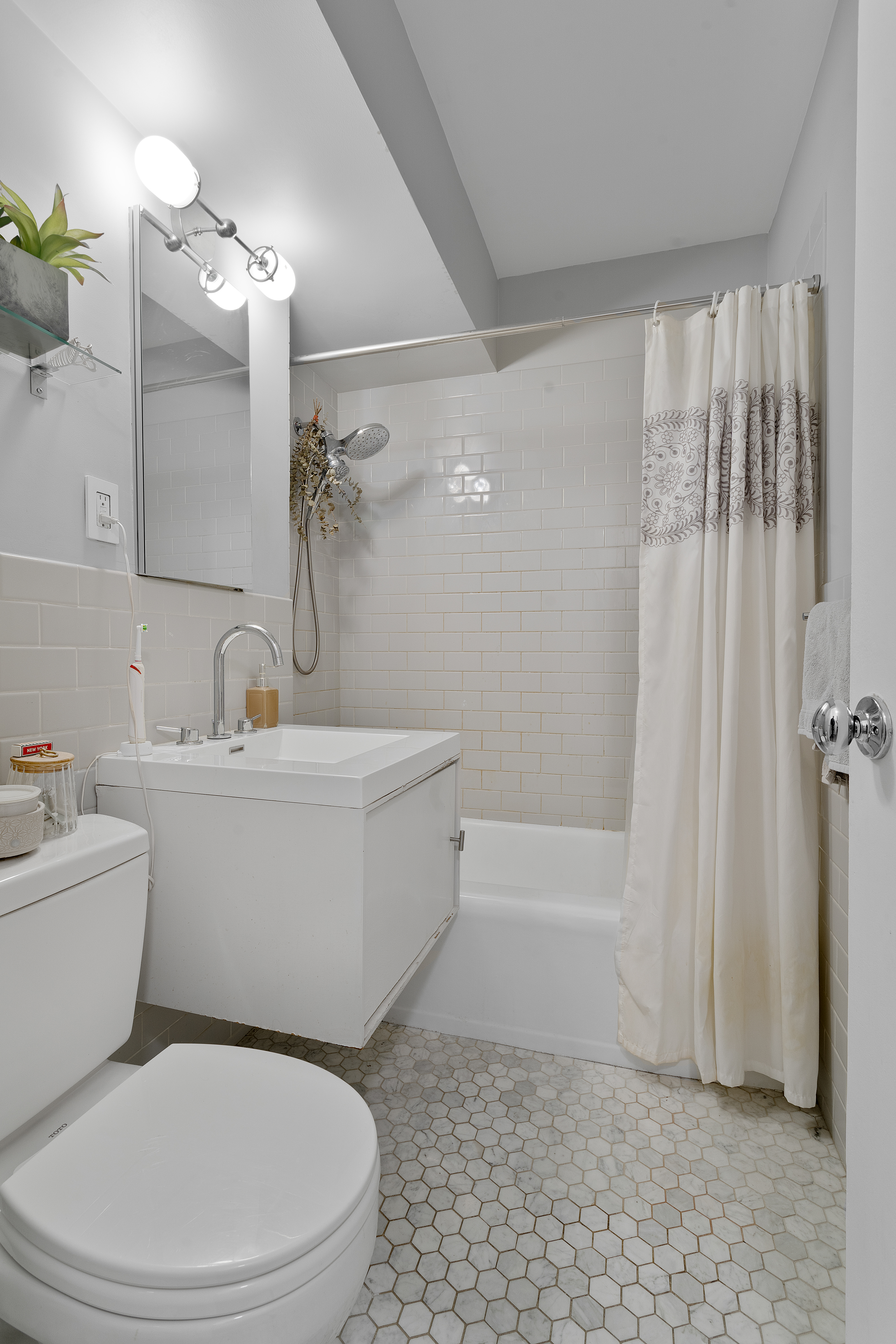 357 East 57th Street, Unit 2E Manhattan, NY 10022 - Photo 10 of 15 a white toilet sitting next to a bath tub