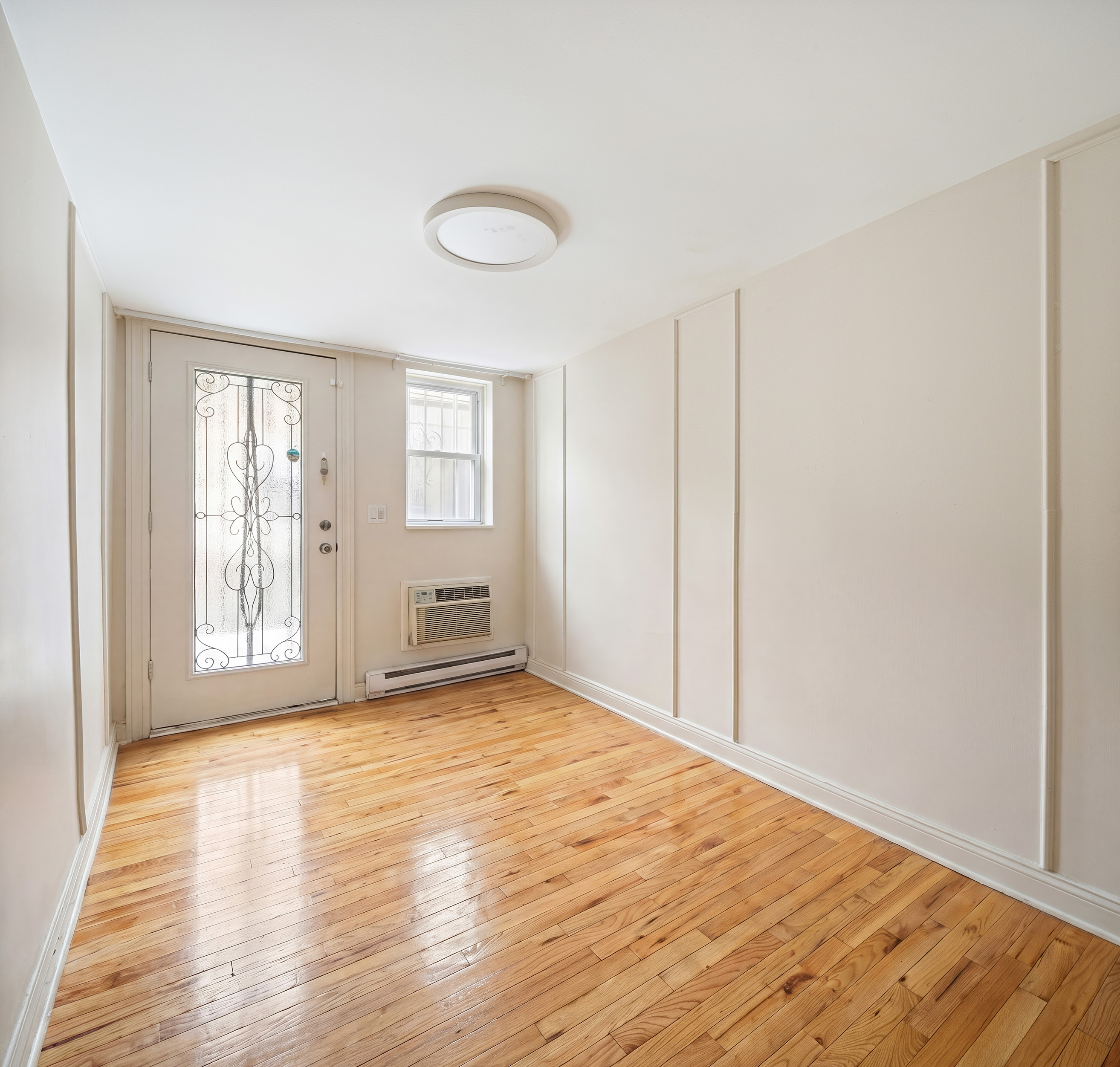 341 West 29th Street, Unit 1 Manhattan, NY 10001 - Photo 7 of 11 a view of an empty room with wooden floor and a window