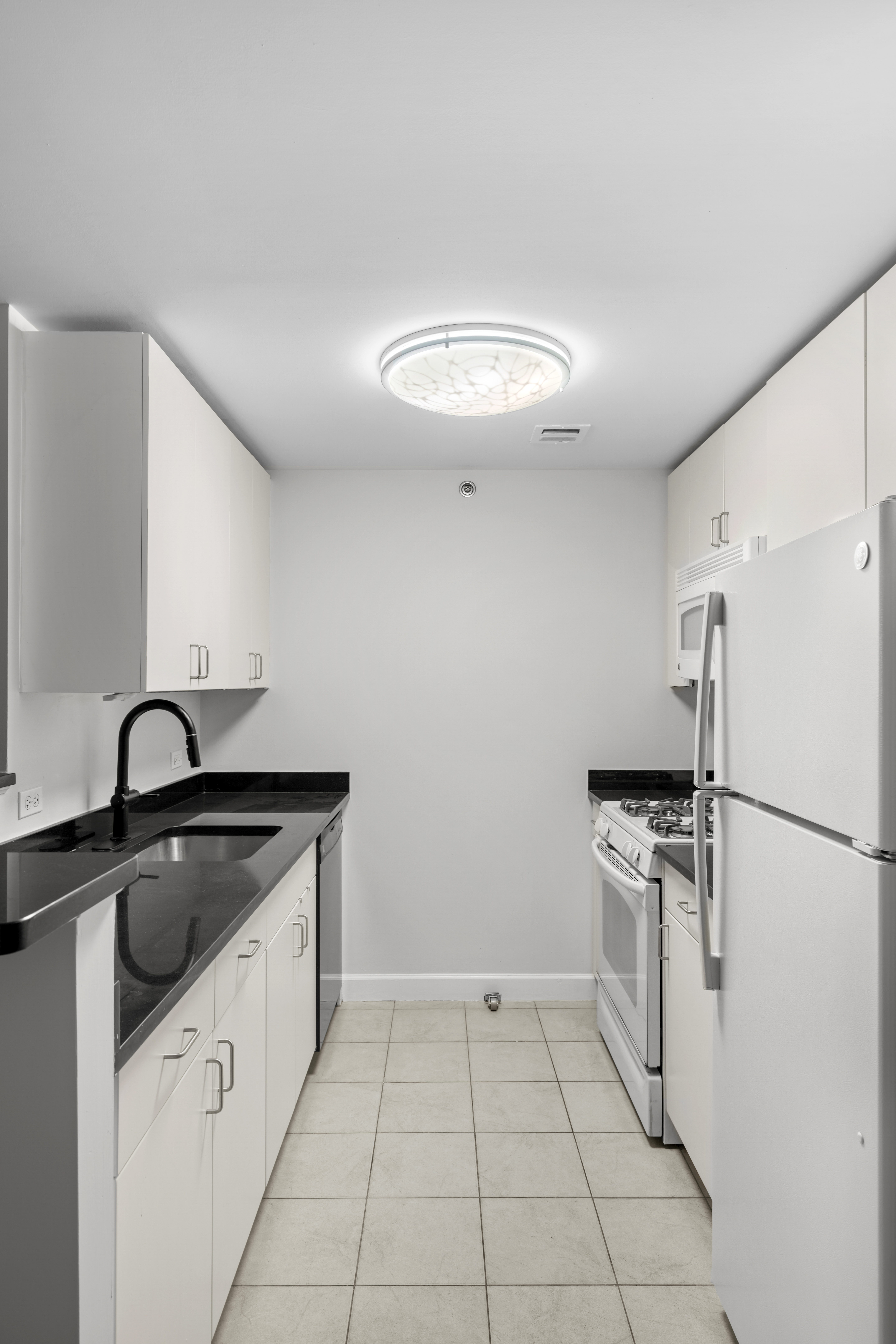 40 West 116th Street, Unit B301 Manhattan, NY 10026 - Photo 6 of 17 a kitchen with granite countertop a sink stove and refrigerator