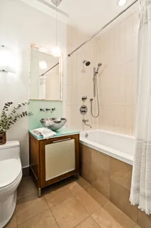 a bathroom with a granite countertop sink a toilet and shower