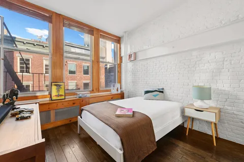 a bedroom with a bed wooden floor and furniture