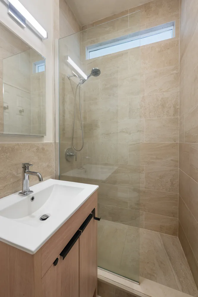 a bathroom with a sink a shower and a mirror