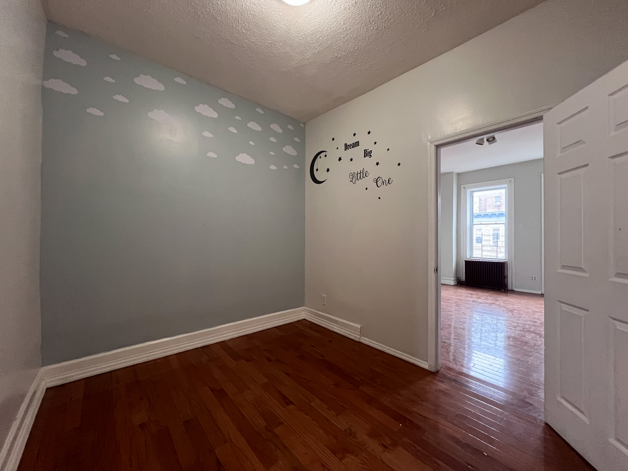 236 45th Street, Unit 2 Brooklyn, NY 11220 - Photo 4 of 8 a view of an empty room with wooden floor and a window