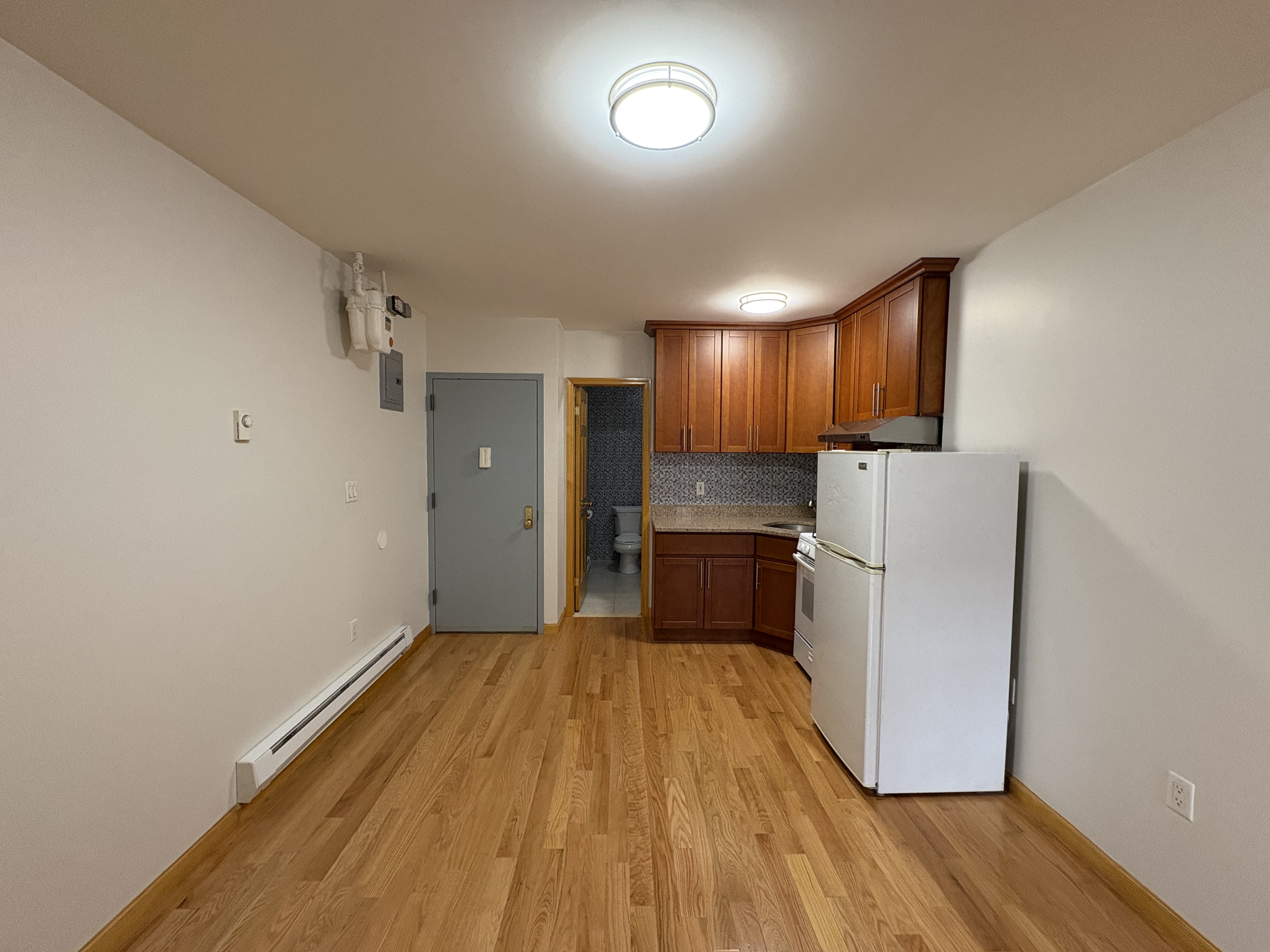 38 Ludlow Street, Unit 15 Manhattan, NY 10002 - Photo 8 of 16 a kitchen with a refrigerator and wooden floor