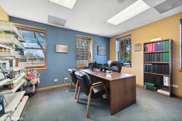 a view of a workspace with furniture and a window