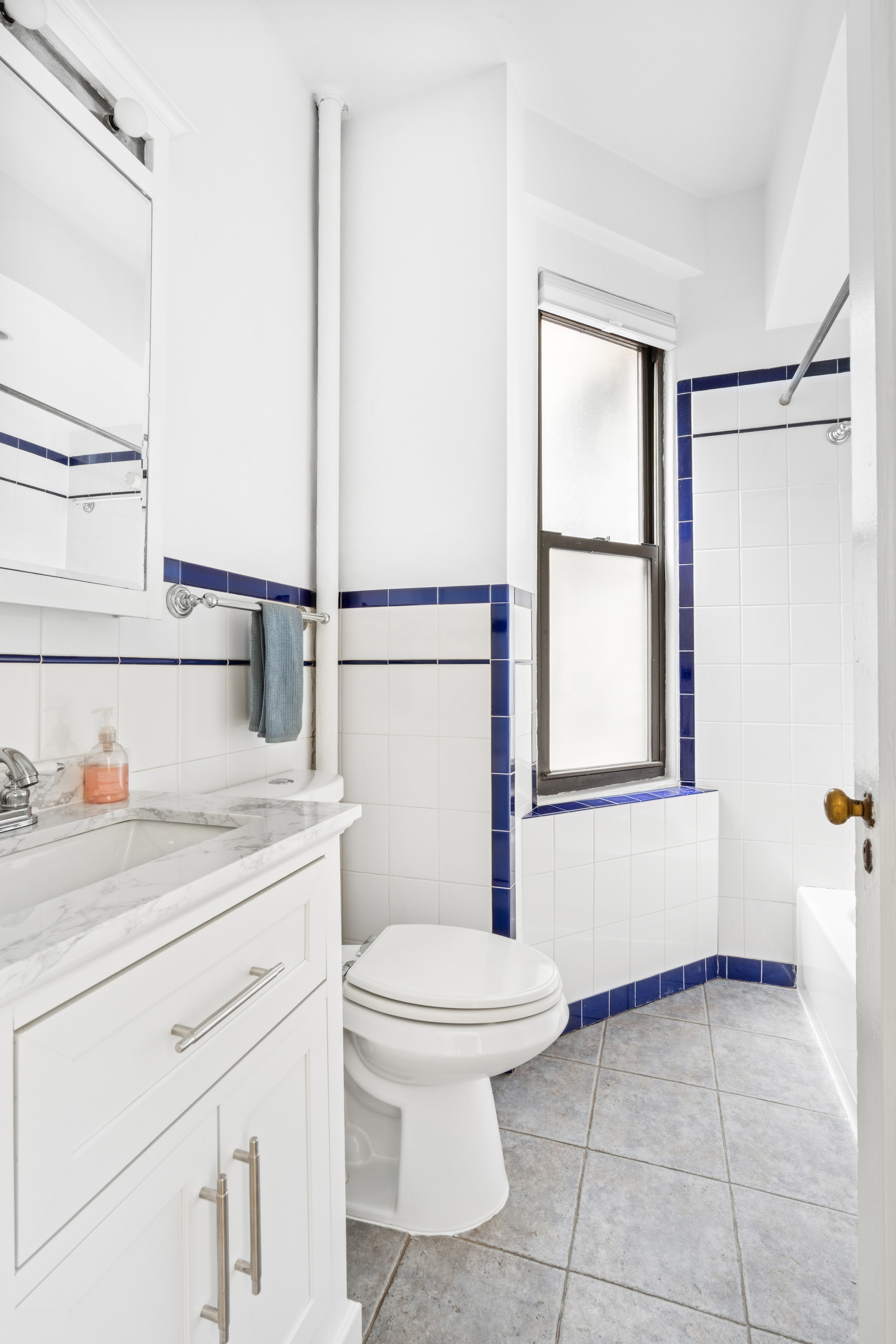 121 East 88th Street, Unit 3A Manhattan, NY 10128 - Photo 5 of 7 a bathroom with a toilet a sink and a window
