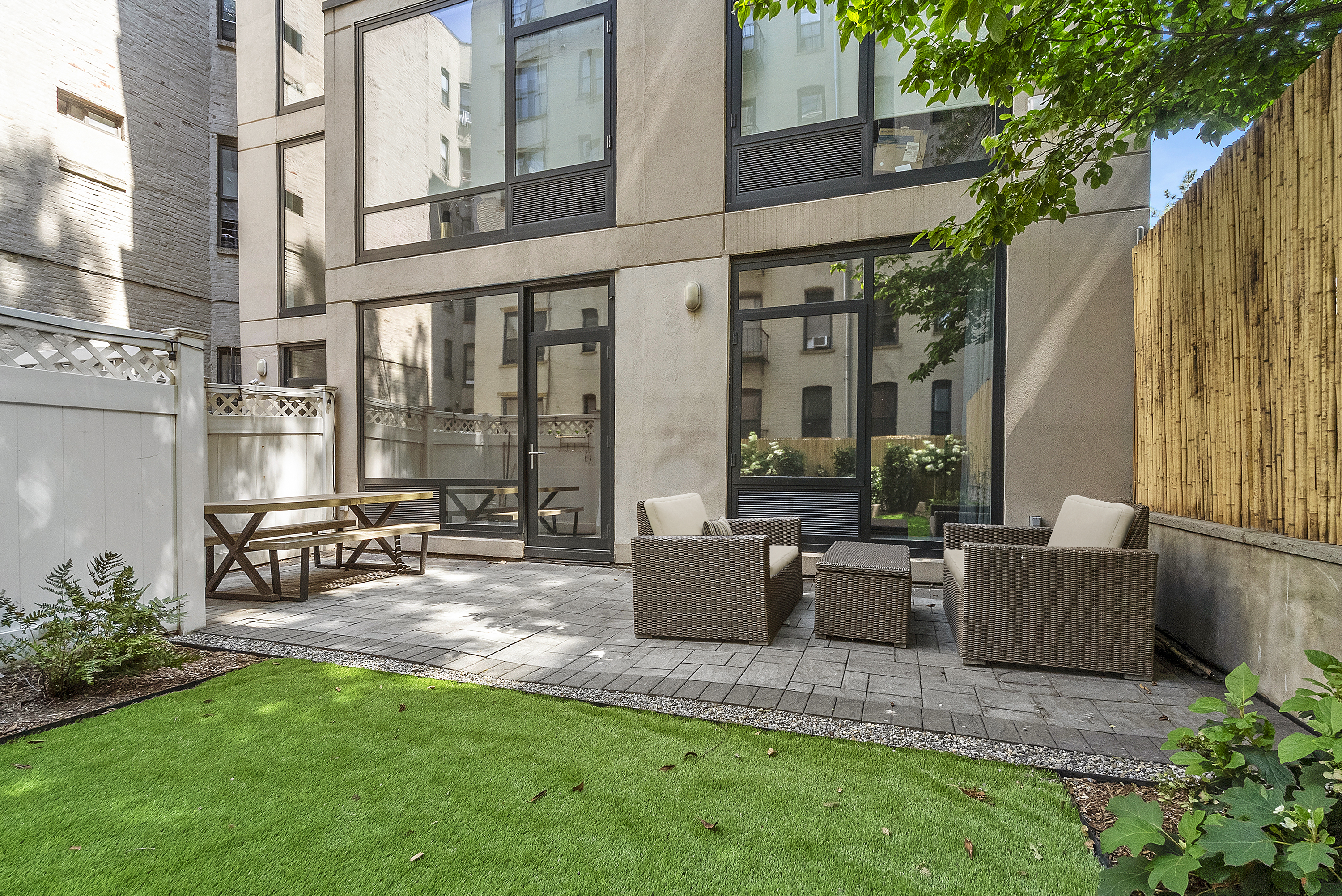 a view of patio with couches table and chairs and potted plants