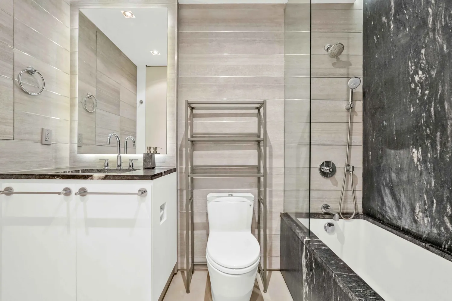 a bathroom with a sink a toilet a mirror and shower