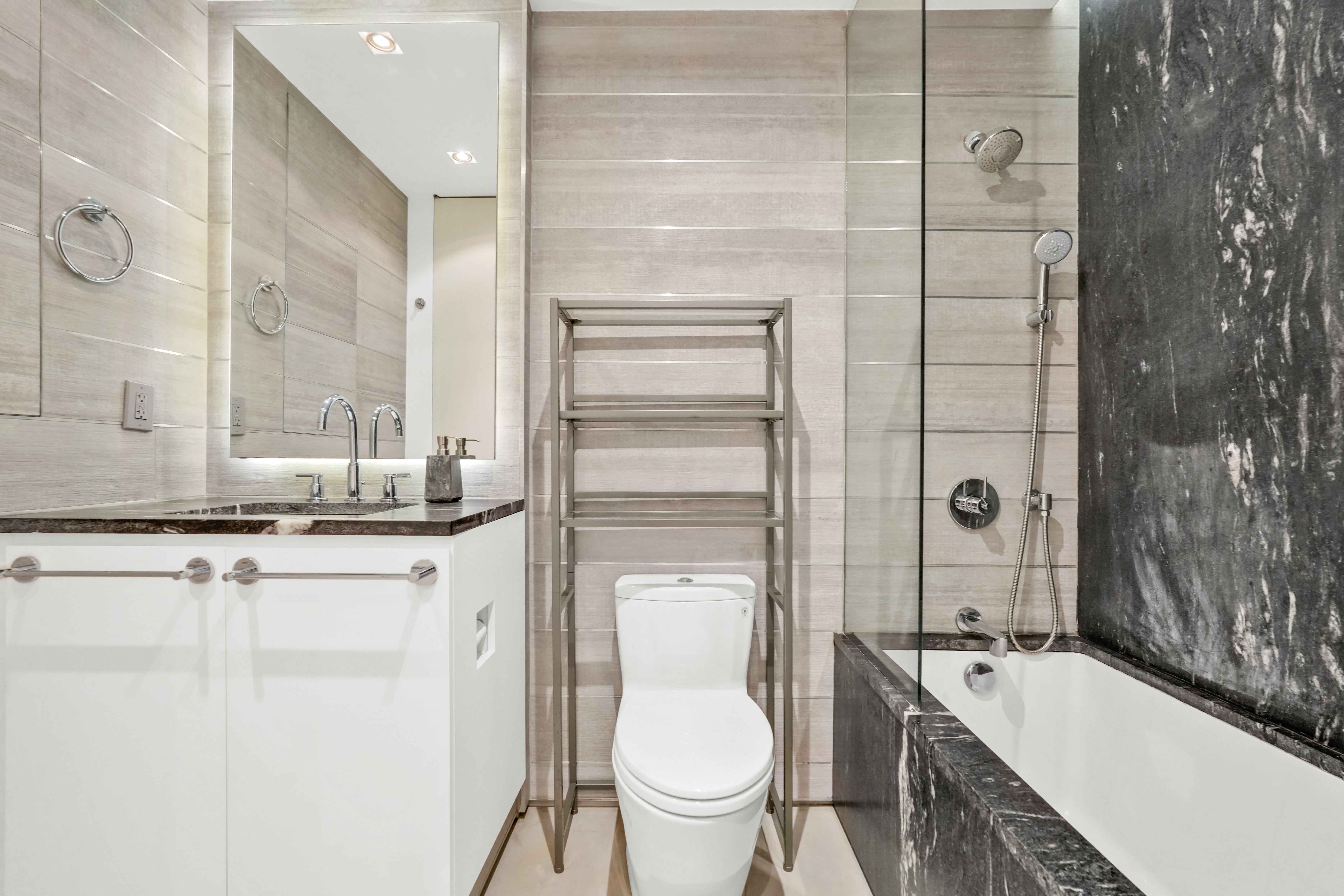 117 East 57th Street, Unit 20F Manhattan, NY 10022 - Photo 11 of 18 a bathroom with a granite countertop sink toilet and shower