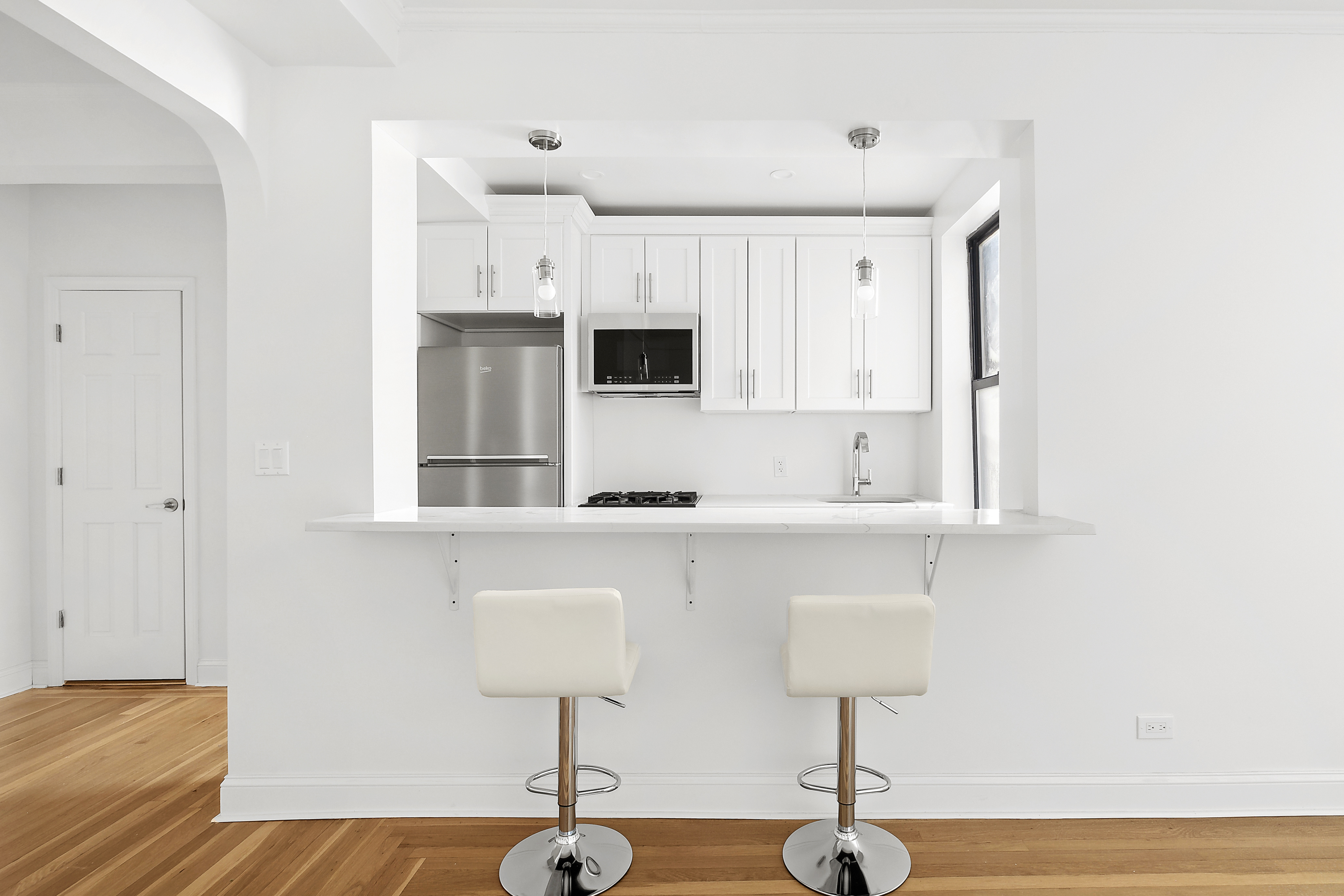 159-34 Riverside Drive West, Unit 7L90 Manhattan, NY 10032 - Photo 7 of 22 a kitchen with stainless steel appliances a sink and cabinets